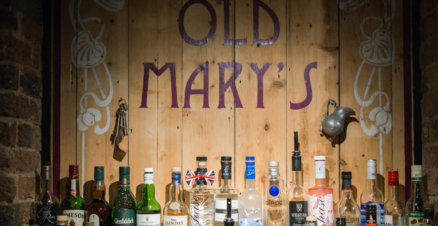 A Number Of Alcoholic Drinks On A Shelf At Old Mary'S The Bar Which Has Halloween Stories Attached To It